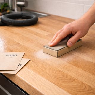 Égrenage manuel d’un plan de travail en bois entre deux couches de vernis